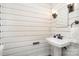 Bathroom featuring white paneling, a pedestal sink, and wall-mounted sconces at 1601 Wandering Way Dr, Charlotte, NC 28226