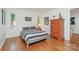 This bedroom offers a hardwood floor, a light-filled window, and a dresser for storage at 1601 Wandering Way Dr, Charlotte, NC 28226