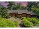 Landscaped home features a stone facade, brown siding and lush green bushes at 1601 Wandering Way Dr, Charlotte, NC 28226