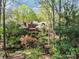 Secluded home surrounded by lush greenery with fenced yard and wooden deck at 1601 Wandering Way Dr, Charlotte, NC 28226