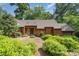 Charming single-story home featuring wood and stone accents with lush landscaping and mature trees in the front yard at 1601 Wandering Way Dr, Charlotte, NC 28226