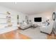 Bright living room with hardwood floors, built-in shelves, and a comfortable gray sectional, creating an inviting space at 1601 Wandering Way Dr, Charlotte, NC 28226