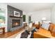 Bright living room with stone fireplace, leather sofa, and a decorative cowhide rug at 1601 Wandering Way Dr, Charlotte, NC 28226