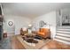 Cozy living room with a leather sofa, decorative rug, and a staircase on the side at 1601 Wandering Way Dr, Charlotte, NC 28226