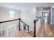 Second-floor landing featuring hardwood floors, white trim, and staircase overlooking the front entrance at 19625 Callaway Hills Ln, Davidson, NC 28036