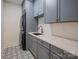 Well-equipped laundry room featuring patterned tile flooring, washer/dryer, sink, and gray cabinetry at 19625 Callaway Hills Ln, Davidson, NC 28036