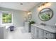 Luxury bathroom with dual vanities, marble countertops, stylish mirrors, and a large window for natural light at 19625 Callaway Hills Ln, Davidson, NC 28036