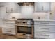 Stainless steel range with custom hood, white subway tile backsplash, and designer cabinets at 19625 Callaway Hills Ln, Davidson, NC 28036