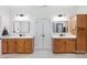 Dual sink bathroom with quartz countertops, wood cabinets, large mirrors and modern fixtures at 2018 Whiskery Ct, York, SC 29745