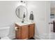 Bathroom featuring a wooden vanity, round mirror, modern lighting and toilet at 2018 Whiskery Ct, York, SC 29745