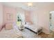 Charming bedroom with twin beds, soft pink walls, and a window with white curtains at 2018 Whiskery Ct, York, SC 29745