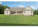 A great view of the back of the home featuring a covered patio and a large, well-kept green lawn at 2018 Whiskery Ct, York, SC 29745
