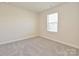 A bedroom features neutral paint, plush carpet, and a window at 213 J.P. Dr, Albemarle, NC 28001