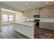 Open kitchen with an island, gray cabinets, stainless steel appliances, and natural light from a window at 213 J.P. Dr, Albemarle, NC 28001