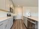 Well-equipped kitchen with stainless steel appliances, sleek gray cabinets, quartz countertops, and wood flooring at 213 J.P. Dr, Albemarle, NC 28001