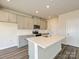 Kitchen showcasing an island with a sink, gray cabinets, stainless steel appliances, and wood flooring at 213 J.P. Dr, Albemarle, NC 28001