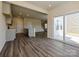 Open concept living space with wood flooring, access to the back patio, and kitchen in the background at 213 J.P. Dr, Albemarle, NC 28001