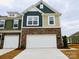 New two-story home with a stone facade, two-car garage, and a mix of siding colors at 222 Harpers Run Ln, Matthews, NC 28104