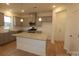 Well-lit kitchen features gray cabinets, granite countertops, an island, and stainless steel appliances at 222 Harpers Run Ln, Matthews, NC 28104