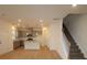 Open-concept living room featuring hardwood floors, recessed lighting, a kitchen view, and staircase at 222 Harpers Run Ln, Matthews, NC 28104