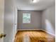 Bright bedroom featuring hardwood floors, neutral walls, and a window overlooking a green outdoor area at 24 19Th Nw St, Hickory, NC 28601