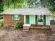 Charming single-story home with brick and siding, and green shutters nestled among mature trees at 24 19Th Nw St, Hickory, NC 28601