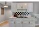 Kitchen features a double basin sink set in white cabinetry with a black and white tiled backsplash at 24 19Th Nw St, Hickory, NC 28601