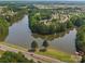 Aerial view showcasing a lake community surrounded by lush trees, a road and community residences at 26444 Sandpiper Ct, Fort Mill, SC 29707