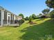 Green backyard features a patio, a sunroom, and beautiful landscaping with a black fence at 26444 Sandpiper Ct, Fort Mill, SC 29707