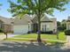 Charming single-Gathering home with manicured lawn, stone accents, and a two-car garage at 26444 Sandpiper Ct, Fort Mill, SC 29707