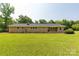 Home's backyard featuring a brick exterior and a spacious grassy yard with trees at 279 Bailey Rd, Lancaster, SC 29720