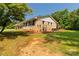 Brick home with a well-manicured lawn, trimmed bushes, and natural landscape at 279 Bailey Rd, Lancaster, SC 29720