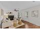 Sunlit living room with a ceiling fan, dark fireplace, and wood floors, creating a warm atmosphere at 2813 Hilliard Dr, Charlotte, NC 28205