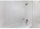 A full white tiled tub and shower with updated fixtures in a neutral colored bathroom at 2819 Georgia Ave, Charlotte, NC 28205