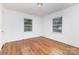 Bright bedroom featuring hardwood floors, two windows, and white walls at 2819 Georgia Ave, Charlotte, NC 28205