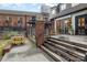 Outdoor patio space with yellow chairs, wooden decking, and brick accents, creating a cozy atmosphere at 2819 Georgia Ave, Charlotte, NC 28205
