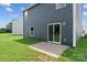 The backyard showcases a concrete patio and lush green lawn with dark siding on the home at 3025 Ora Smith Rd, Lincolnton, NC 28092