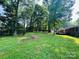 Picturesque backyard featuring mature trees, a grassy area, and a wooden deck at 316 Meadowood Cir, Kannapolis, NC 28081