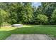 Lush backyard featuring an above-ground pool, a flat grassy area, and bordered by a wooden fence and mature trees at 3505 Mallard Cove Ct, Charlotte, NC 28269