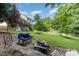 Relaxing backyard with a fire pit, lush green lawn, mature trees, and a back deck with an above-ground pool at 3505 Mallard Cove Ct, Charlotte, NC 28269