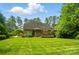 Spacious backyard with lush lawn, mature trees, and a brick home with a deck at 3735 Gordon St, Terrell, NC 28682