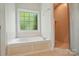 Bright bathroom featuring a soaking tub under a window and a separate glass-enclosed shower at 3735 Gordon St, Terrell, NC 28682