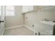 Functional laundry room with a utility sink, storage cabinets, and tile flooring near a window at 3735 Gordon St, Terrell, NC 28682