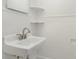 This bathroom features a white pedestal sink, tiled walls, and decorative shelving at 3939 Sheffield Dr, Charlotte, NC 28205