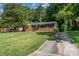 Charming brick home with mature trees, a well-maintained lawn, and a private driveway at 3939 Sheffield Dr, Charlotte, NC 28205