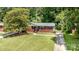 Beautiful brick home with lush green lawn and mature trees offering shade at 3939 Sheffield Dr, Charlotte, NC 28205