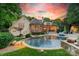 Stunning backyard with a swimming pool, stone patio, manicured landscaping, and serene outdoor seating areas at 4001 Doves Roost Ct, Charlotte, NC 28211