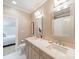 Bright bathroom featuring double sinks, framed mirrors, and neutral tones with a view into another room at 4001 Doves Roost Ct, Charlotte, NC 28211