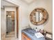 Stylish bathroom with a unique mirror, stone countertop, and a glass-enclosed shower at 4001 Doves Roost Ct, Charlotte, NC 28211