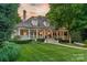 Inviting home featuring a manicured lawn, covered porch, and classic architectural details at 4001 Doves Roost Ct, Charlotte, NC 28211